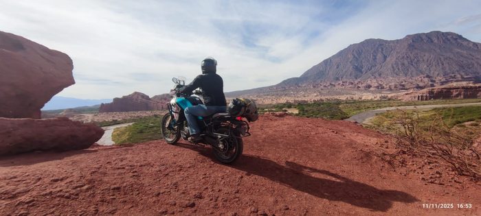 Rider con equipaje avanzando por un camino de tierra roja